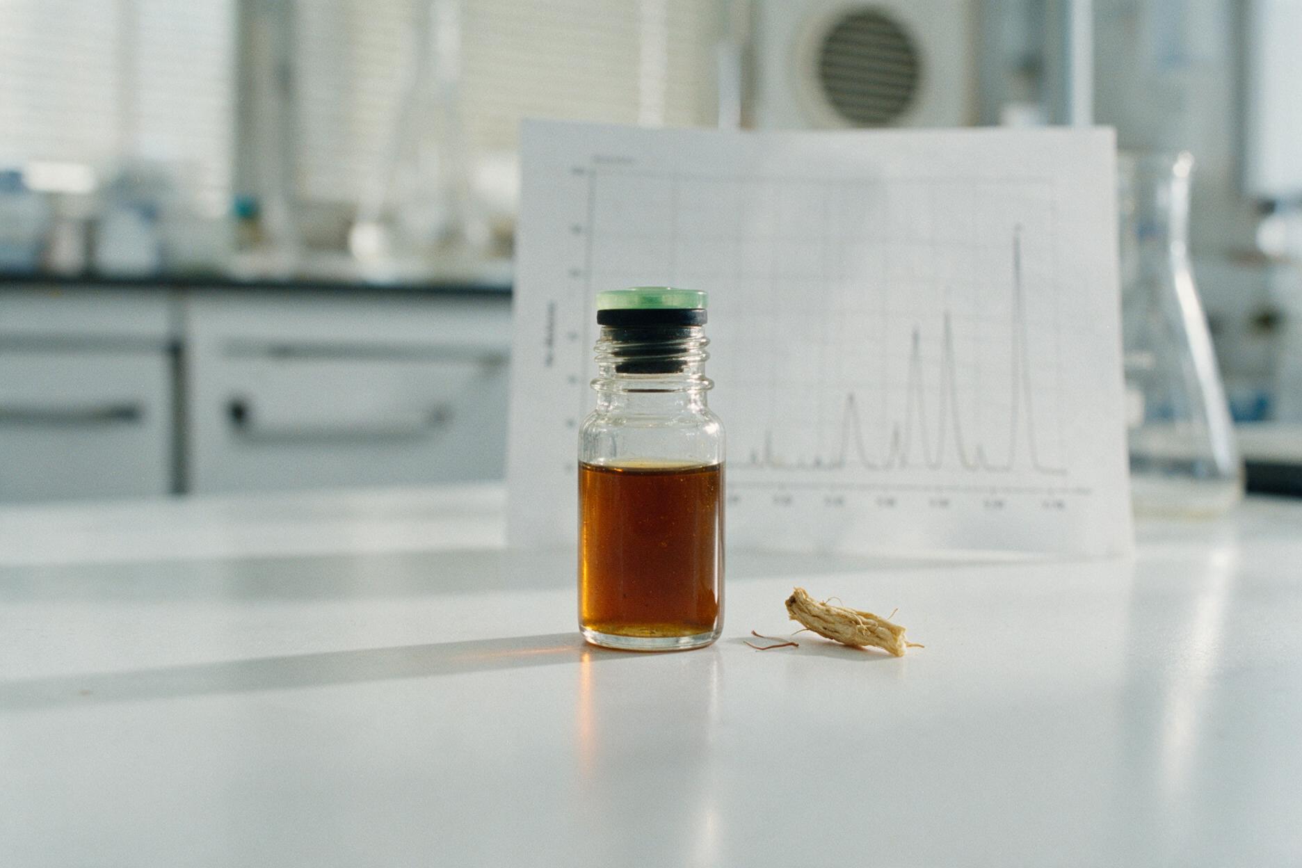 Laborprobe mit Kava-Extrakt in einem Vial vor einem HPLC-Chromatogramm-Ausdruck